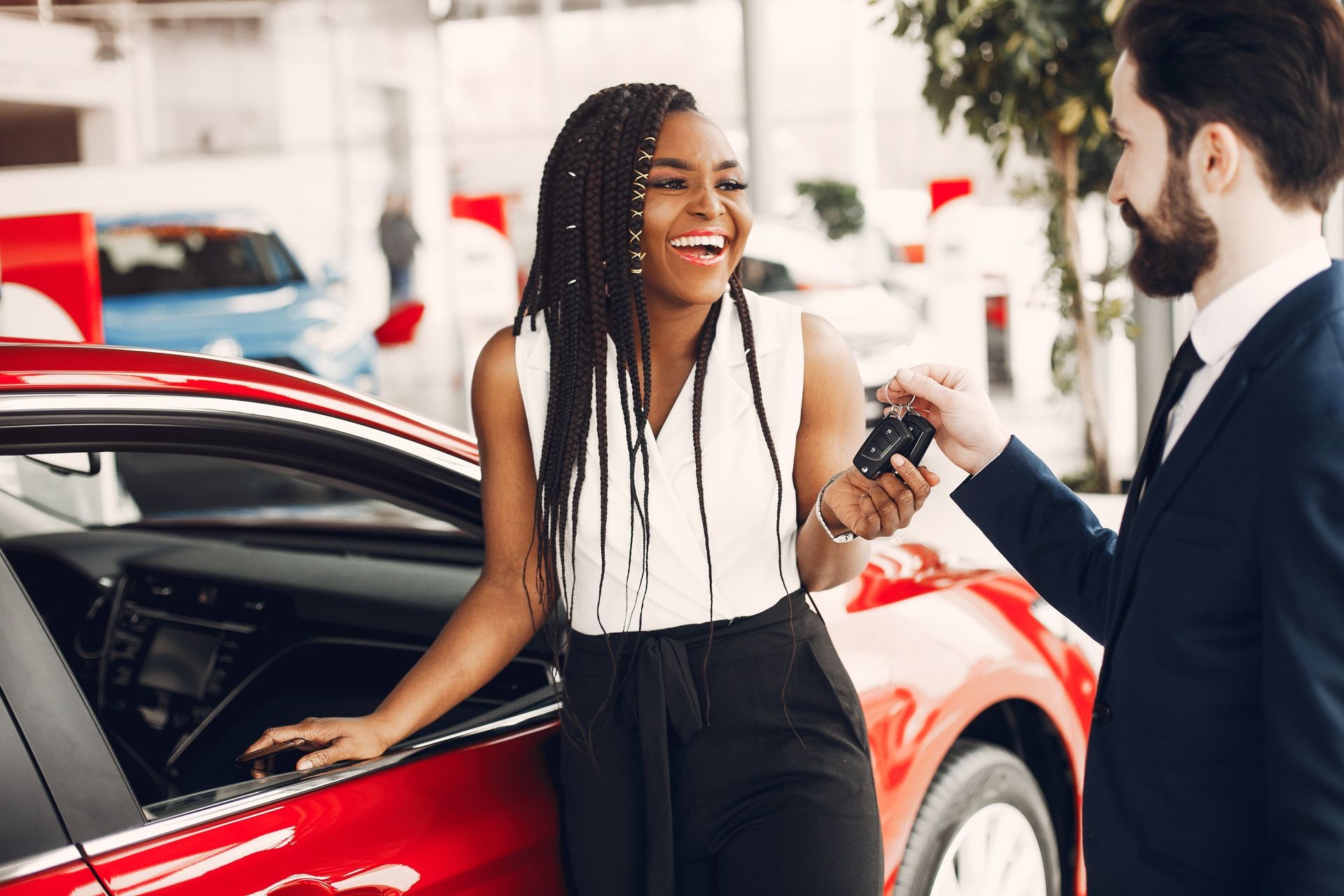 Woman buying the car. Lady in a car salon. Manager with a clients